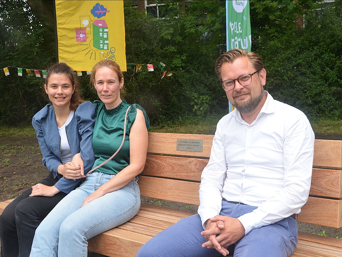 Wethouder Eelco Eikenaar met Reza's vrouw en dochter op het herinneringsbankje. "Reza wordt gemist maar niet vergeten", had hij even eerder in zijn openingstoespraak gezegd